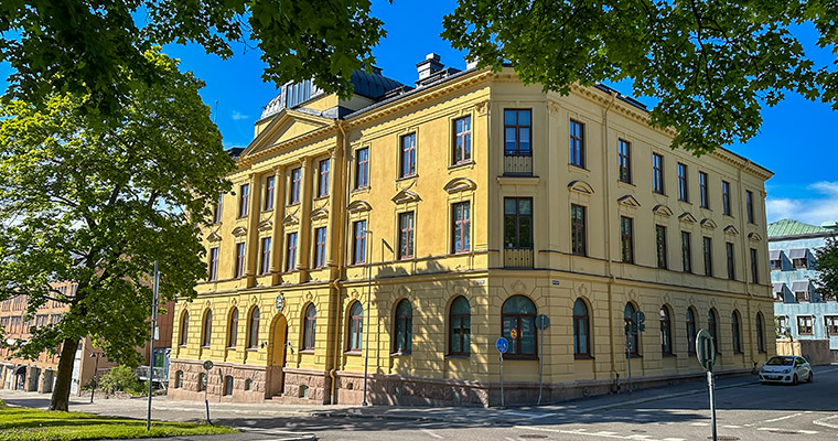 Gult stenhus, grönt lövträd