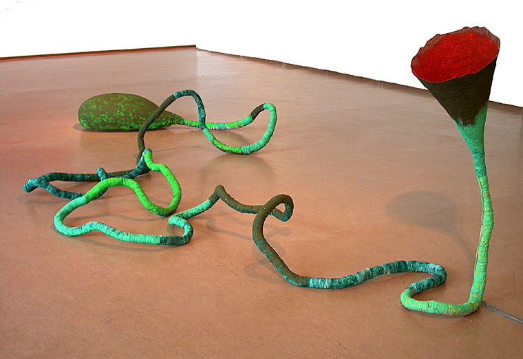 Bild på installationen Vox humana, en tratt i form av en flera meter lång slingrig grön stjälk med en röd blomma.