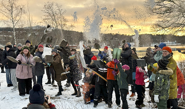en stor grupp människor med spadar i händerna kastar upp snö i luften